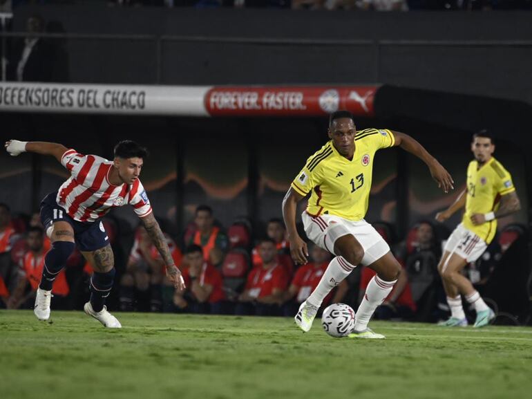 Adam Bareiro, de Paraguay, disputa el balón con Yerry Mina, de Colombia.