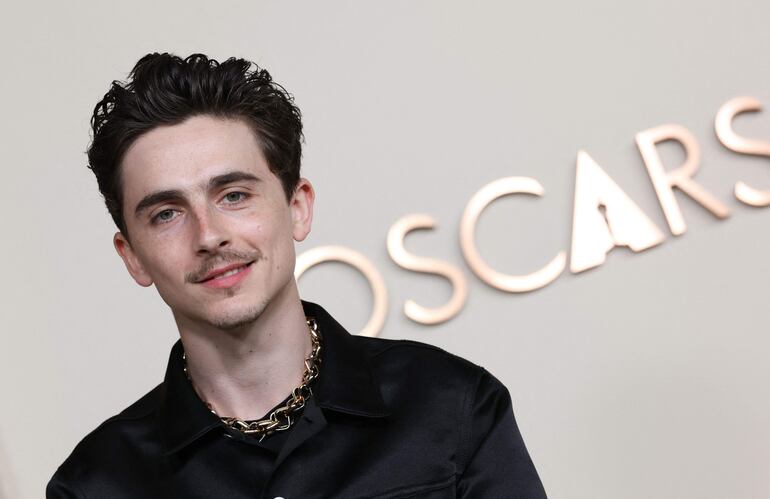 El joven y famoso actor Timothée Chalamet muy sonriente a su arribo a la edición número 97 de la Cena Anual de Nominados a los Premios de la Academia. (VALERIE MACON / AFP)