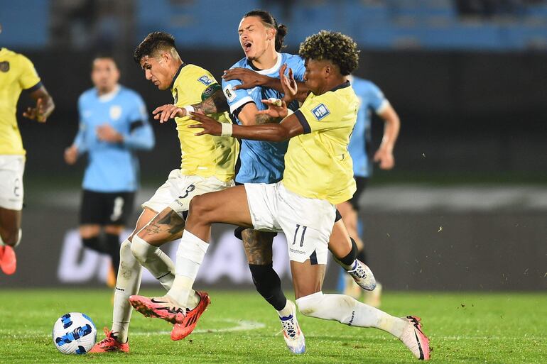 El delantero de Uruguay, Darwin Nunez (c) disputa la posesión del balón con los ecuatorianos Piero Hincapie y Kevin Rodríguez.