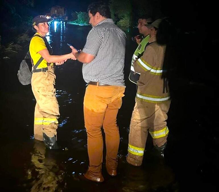 Bomberos Voluntarios de Caapucú, en compañía del intendente local Gustavo Penayo (ANR), en momento que estaban evacuando a los damnificados.