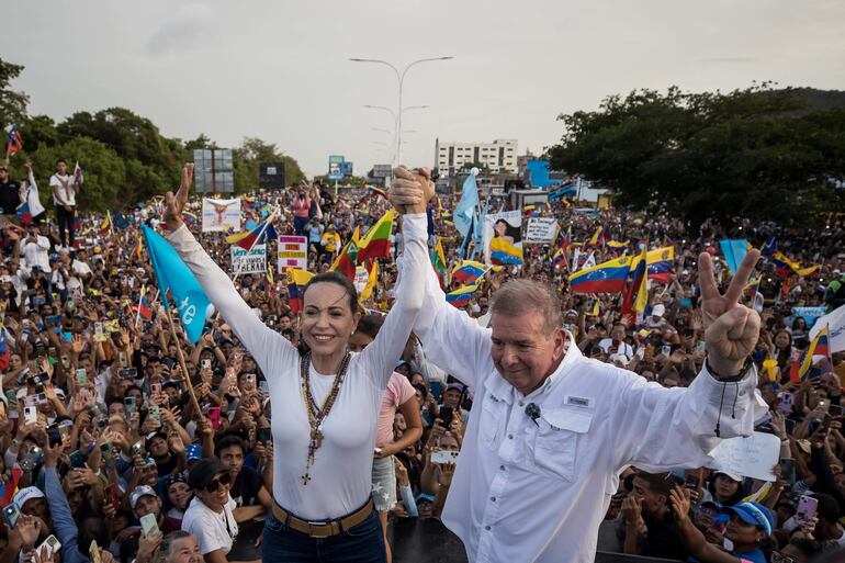 El candidato a la Presidencia de Venezuela, Edmundo González (d), y la líder opositora venezolana María Corina Machado, saludan a seguidores en un acto de campaña, el 10 de julio de 2024, en Puerto La Cruz (Venezuela). 