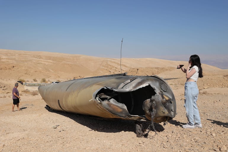 Imagen ilustrativa: gente revisa los restos de un misil balístico iraní en las afueras de la ciudad de Arad, en el sur de Israel.