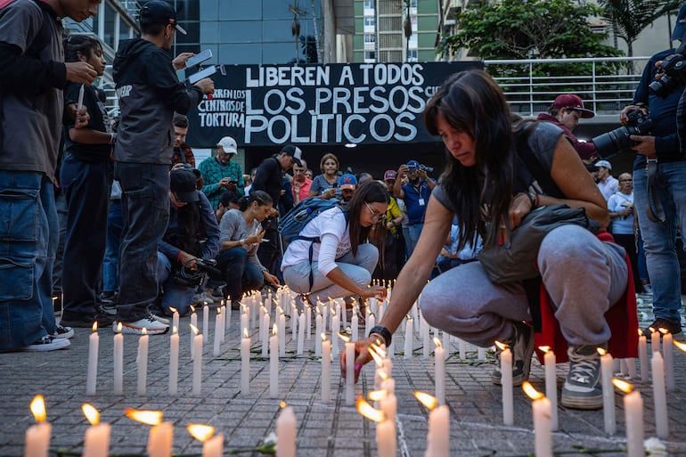 Personas prenden velas durante la gran vigilia nacional por los presos políticos convocada por la oposición, este jueves en la plaza Los Palos Grandes, en Caracas (Venezuela).