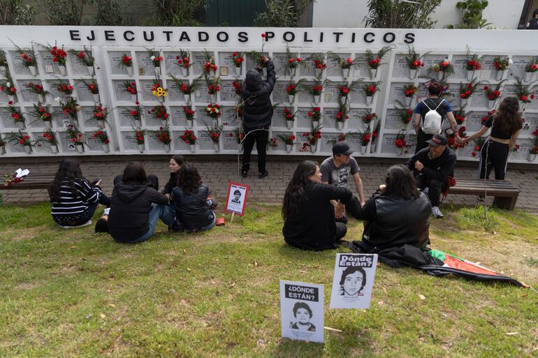 Personas observan los sepulcros de personas de desaparecidas en el Memorial del Detenido Desaparecido y del Ejecutado Político, este domingo, en Santiago (Chile).