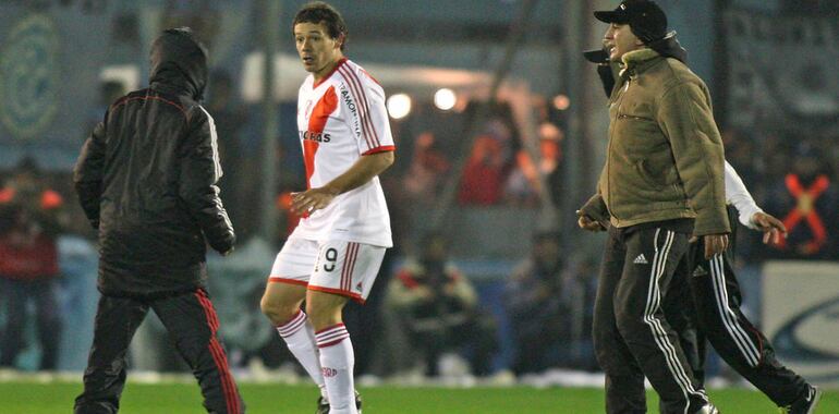 Adalberto Román, jugador paraguayo, en pleno partido, enfrenta a los barras que invadieron el campo.