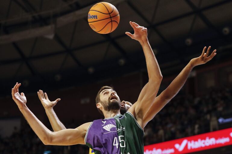 El pívot búlgaro David Kravish (c-i) del Unicaja en acción ante el pívot estadounidense Trevor Thompson (c-d), durante un partido de la Liga de Campeones entre el Unicaja y el Peristeri, en Málaga (Andalucia).