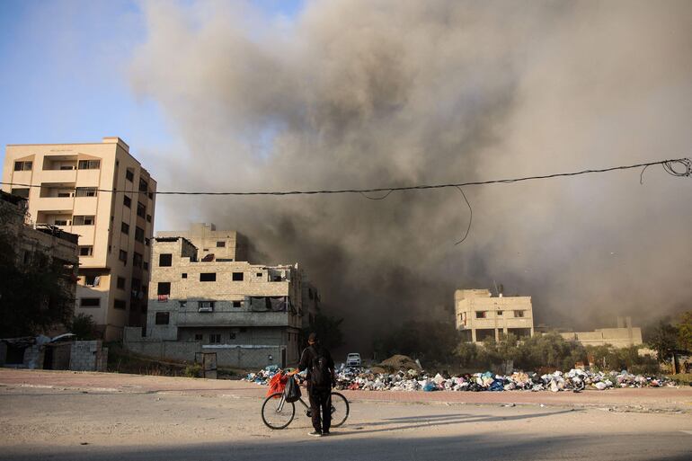 Un hombre mira una columna de humo después del bombardeo israelí en el barrio de Al-Daraj en la ciudad de Gaza el 16 de abril de 2024, en medio de las batallas en curso entre Israel y el movimiento palestino Hamas.