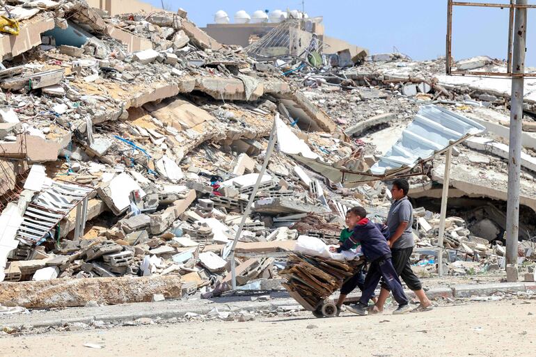 Niños palestinos recojen madera y cartón en Beit Lahya, en el norte de la Franja de Gaza, este sábado.