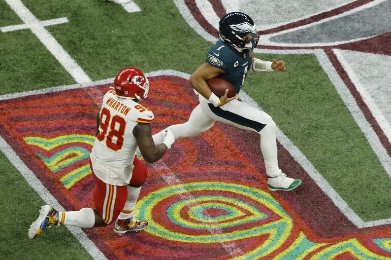 El mariscal de campo de los Philadelphia Eagles Jalen Hurts (R) lucha por yardas lejos del equipo defensivo de los Kansas City Chiefs Tershawn Wharton (L) durante la segunda mitad del Super Bowl LIX entre los Kansas City Chiefs y los Philadelphia Eagles en el Caesars Superdome de Nueva Orleans, Luisiana, EE.UU.