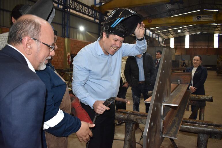 El ministro de Industria, Javier Giménez, realiza trabajos de soldadura en el local de la metalúrgica Domec SA.