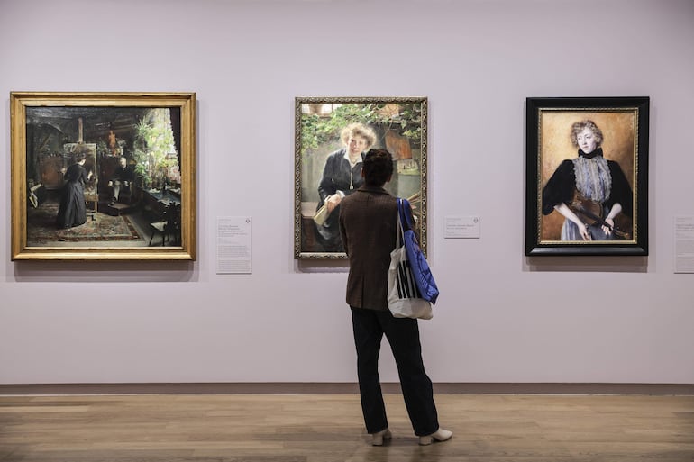 Una mujer observa diversas pinturas de artistas escandinavas durante la gira de prensa de la exposición 'Harriet Backer. La música de los colores' en el Museo de Orsay en París.