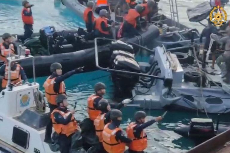 Captura de un vídeo publicado por las Fuerzas Armadas de Filipinas que muestra a guardias costeros chinos  que parecen amenazar con armas blancas a marinos filipinos cerca del atolón Second Thomas, en el mar de China Meridional.