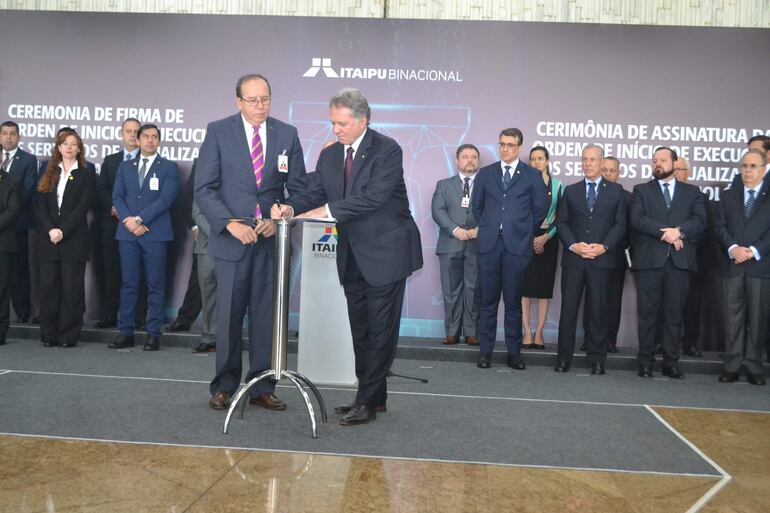 El acto de firma de la orden de inicio del plan de actualización tecnológica de Itaipú contó con la presencia del ministro de Relaciones Exteriores de Brasil, Carlos Franco França, así como de su par de Minas y Energía, almirante Bento Albuquerque y el director general del máximo órgano regulador del sistema eléctrico del vecino país Aneel, André Pepitone. En la foto, el director general paraguayo, Manuel María Cáceres, y firmando el documento, su homólogo brasileño, Anatalicio Risden Junior, rodeados por directivos de la Itaipú