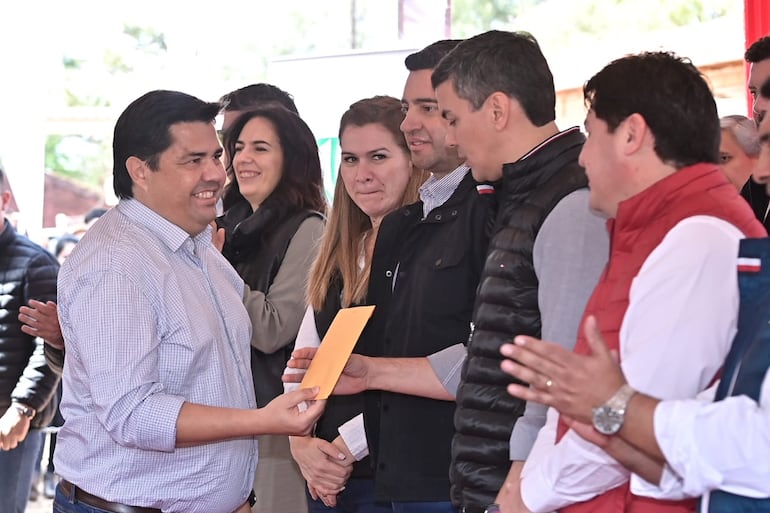 El director  de la EBY, Luis Benítez, entrega un sobre al presidente de la República, Santiago Peña.