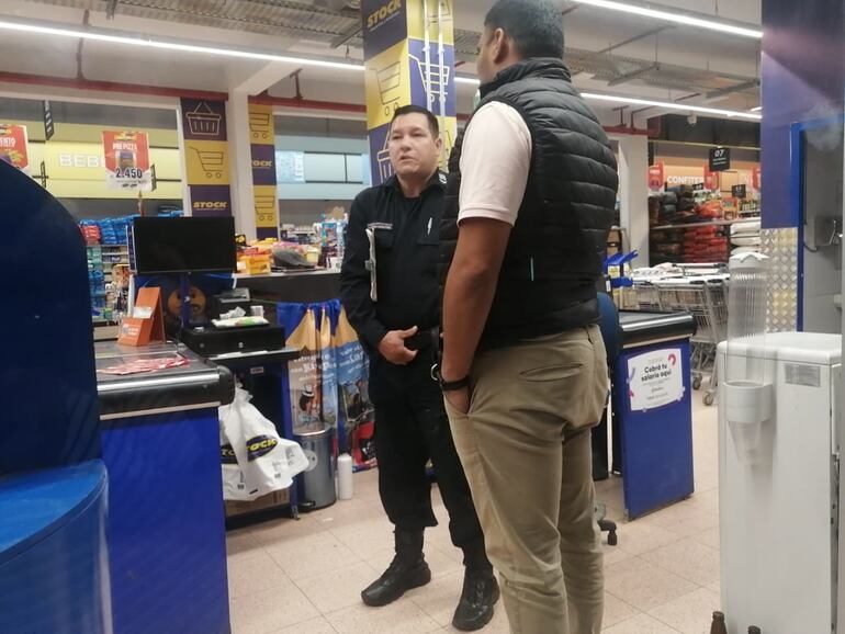 Efectivos policiales se encuentran en el interior del supermercado para observar la cámara de circuito cerrado.