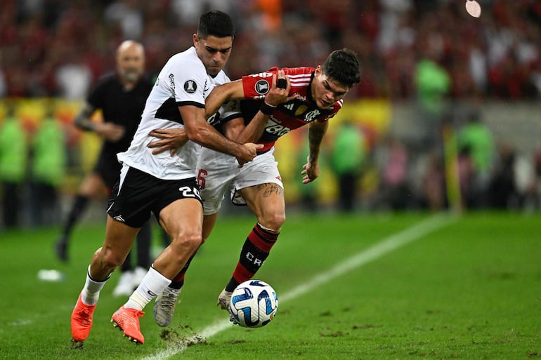 El paraguayo Brian Montenegro (i), jugador de Olimpia, pelea por el balón en el partido contra Flamengo por la ida de los octavos de final de la Copa Libertadores 2023 en el estadio Maracaná, en Río de Janeiro, Brasil. 