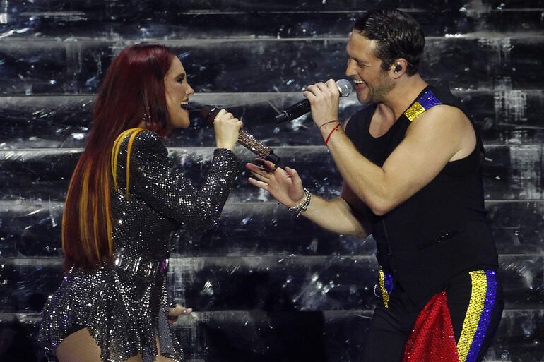 Dulce María y Chistopher Uckerman cantando juntos en un momento del show de RBD, la agrupación musical surgida de la telenovela mexicana "Rebelde".