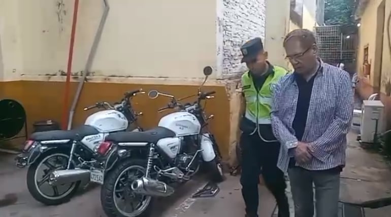 Froilán Peralta, aparece esposado siendo trasladado por un agente policial esta mañana.