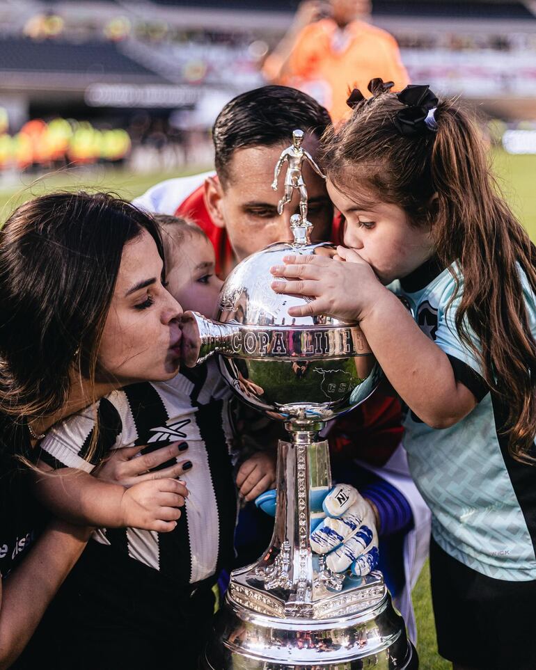 "Gatito" Fernández con su esposa Silvia Santander y sus hijas Sophie y Rafaella besando la Copa Libertadores de América. (Instagram/Gatito Fernández)