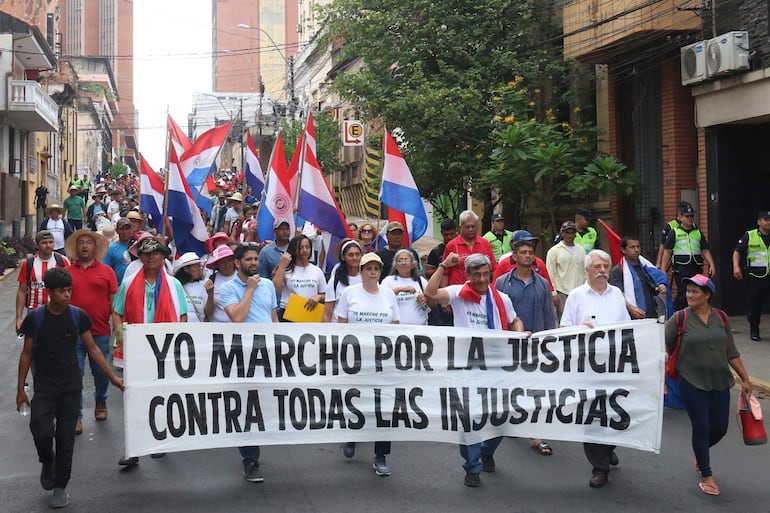 Manifestantes durante la marcha 'Por la Justicia, contra toda la injusticia' organizada por opositores y organizaciones de la sociedad civil recorrieron el pasado 21 de noviembre las calles de Asunción y entregaron una proclama a los tres poderes del Estado. (EFE).