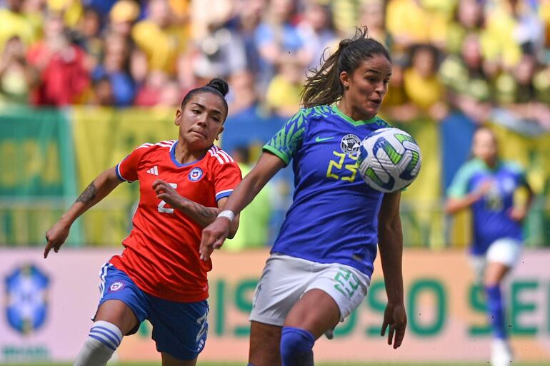 Gabi Nunes (d) de Brasil disputa un balón con Michelle Olivares de Chile, en un partido amistoso entre Brasil y Chile en el estadio Mané Garrincha en Brasilia (Brasil). Brasil se prepara para competir en la Copa Mundial Femenino 2023. EFE/ Andre Borges