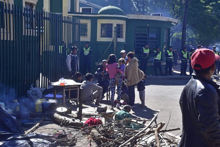 Con un fuerte resguardo policial, se encuentran indígenas abandonados en la vereda del Indi, sobre la avenida Artigas en Asunción.