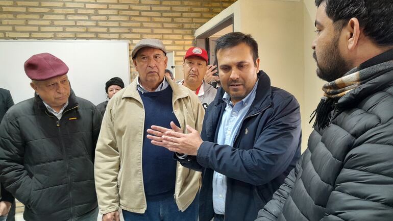 El director de infraestructura del Mec, ingeniero Víctor Hugo Villasboa, dialoga con los padres y el concejal, Marcelo MArtínez, escucan atentamente el director de obras de la municipalidad, ingeniero Hugo Delvalle y el propietario de Fenar, Nery Rumich.