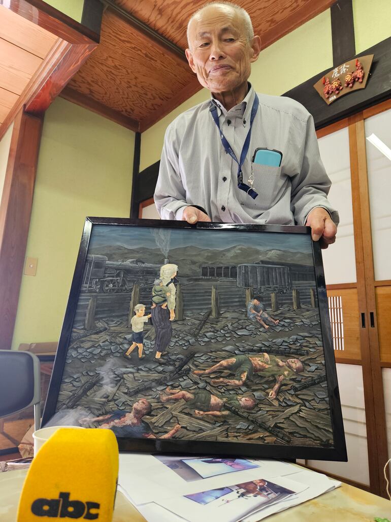 Nobel de la paz 2024,  Mimaki Toshiyuki muestra una pintura que eterniza su testimonio sobre el impacto de la bomba atómica sobre Hiroshima. 