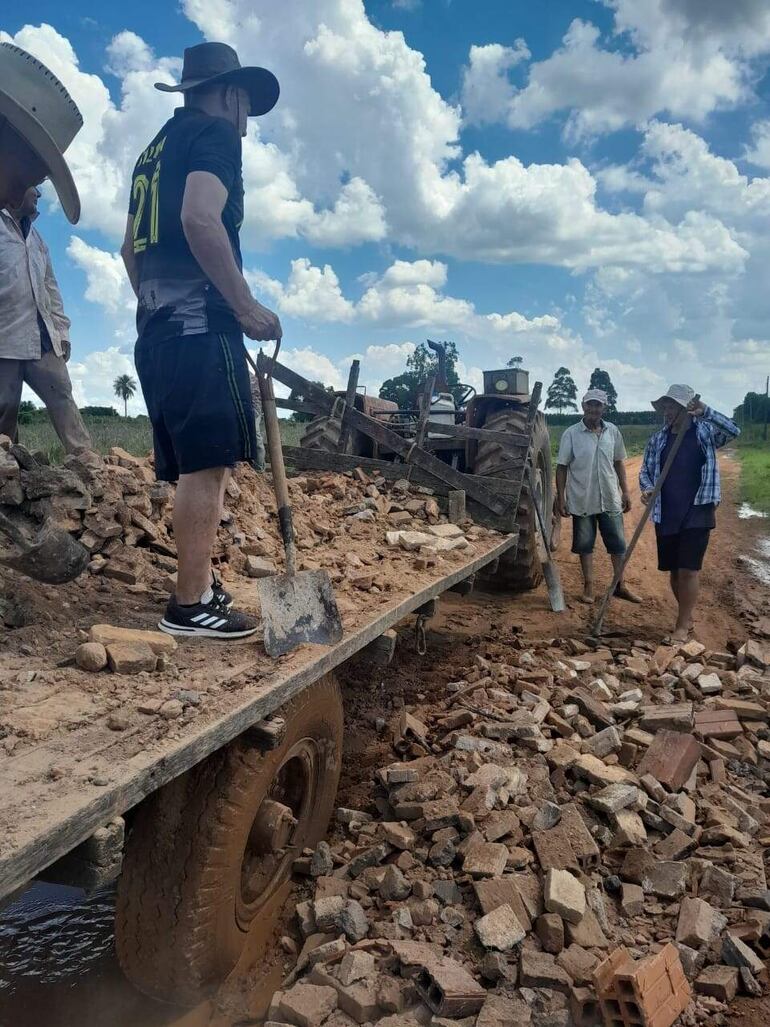 Los pobladores de la compañía San Roque tapando los baches profundo del camino de la localidad.