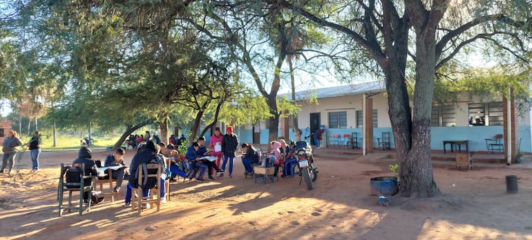 Estudiantes de la escuela Nueva Asunción de Chacó'i dan clases bajo un árbol y comparten la pizarra entre varos grados.