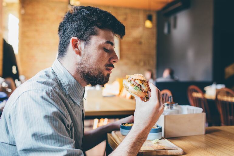 Un hombre comiendo una hamburguesa