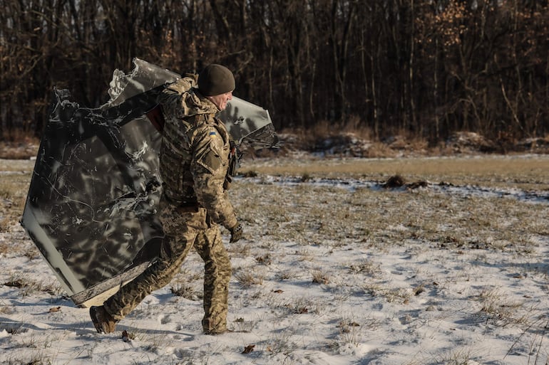 Un soldado ucraniano lleva una pieza de un dron Shahed derribado cerca de Kiev. (Imagen de archivo)