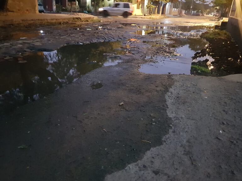 Calle destrozada e inundada en Asunción.