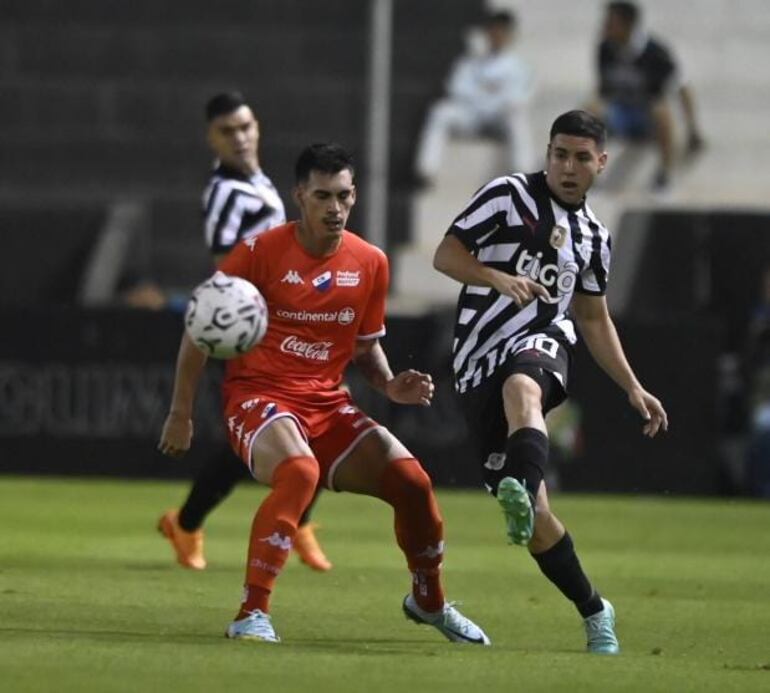 Fernando Román, de Nacional, disputa el balón con Enso González, de Libertad.