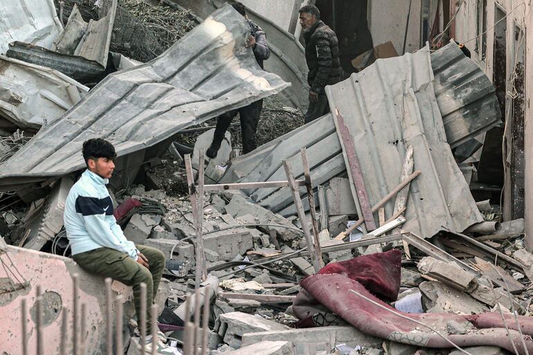 Un hombre sentado entre escombros luego de un bombardeo israelí sobre Rafah, en el sur de la Franja de Gaza, este jueves.