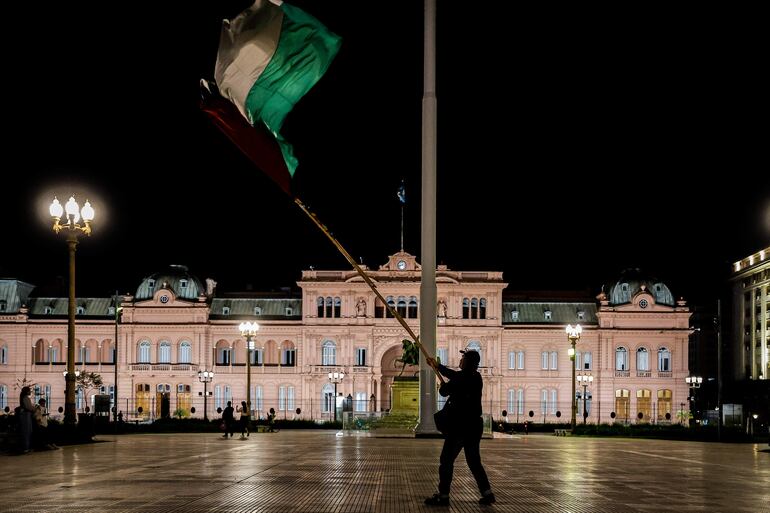 Un hombre sostiene una bandera durante una vigilia por el pueblo Palestino este domingo en la Plaza de Mayo de Buenos Aires (Argentina).