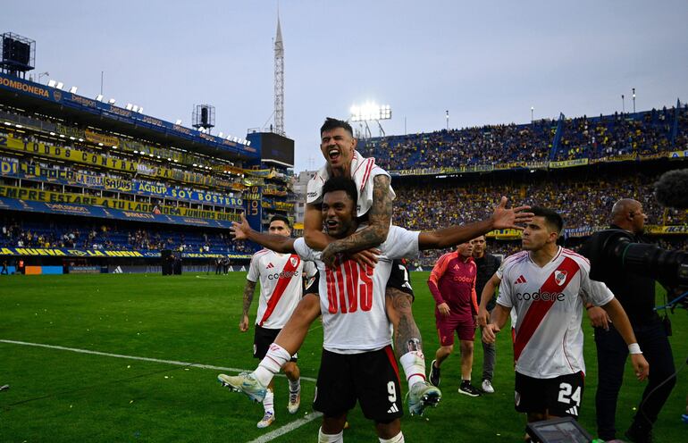 River Plate's Paraguayan forward Adam Bareiro (top) and River Plate's Colombian forward Miguel Borja (9) celebrate after winning the 2024 Argentine Professional Football League tournament match between Boca Juniors and River Plate at the Alberto Jose Armando 'La Bombonera' stadium, in Buenos Aires on September 21, 2024. (Photo by LUIS ROBAYO / AFP)