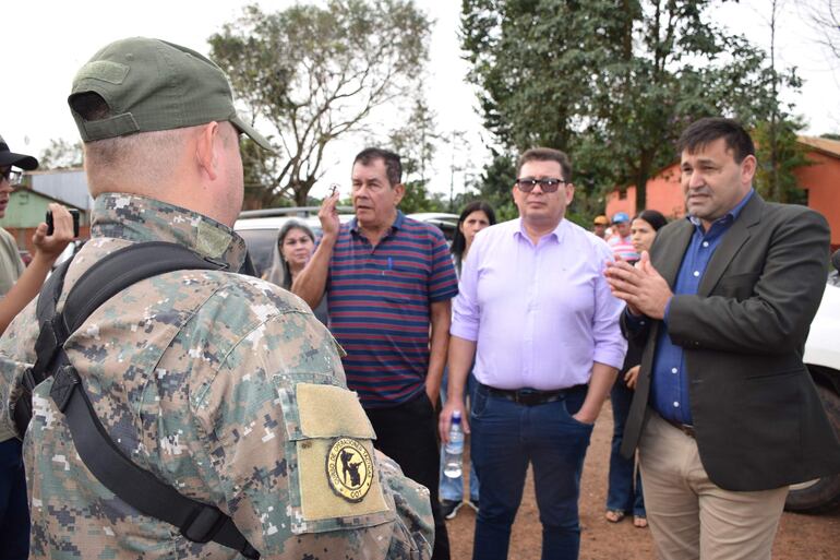 El intendente municipal Carlos Carvallo (camisa clara) hablando con los efectivos policiales antes del desalojo.