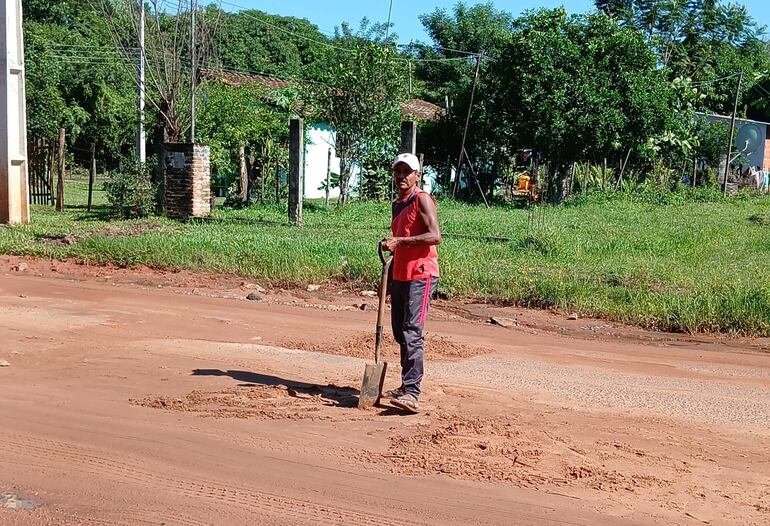 Mariano Mato, un vecino de la compañía Itapuami, trabajando por la calle y cargando ripio para nivelarla.