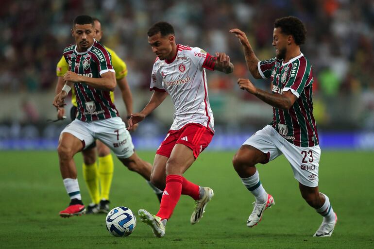 Guga (d) de Fluminense disputa el balón con Allan Patrick (c) de Internacional hoy, en un partido de las semifinales de la Copa Libertadores entre Fluminense e Internacional en el estadio Maracaná en Río de Janeiro (Brasil).