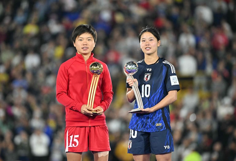 North Korea's forward Il Son Choe (L) and Japan's forward Manaka Matsukubo pose with the best players of the tournament trophies after the 2024 FIFA U-20 Women's World Cup final match between North Korea and Japan at the Nemesio Camacho 'El Campin' stadium in Bogota, on September 22, 2024. (Photo by Luis ACOSTA / AFP)