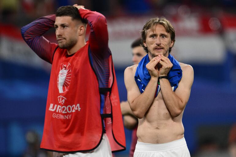 TOPSHOT - Croatia's midfielder #10 Luka Modric (R) reacts to their probable championship exit on the pitch after the UEFA Euro 2024 Group B football match between the Croatia and Italy at the Leipzig Stadium in Leipzig on June 24, 2024. (Photo by Christophe SIMON / AFP)