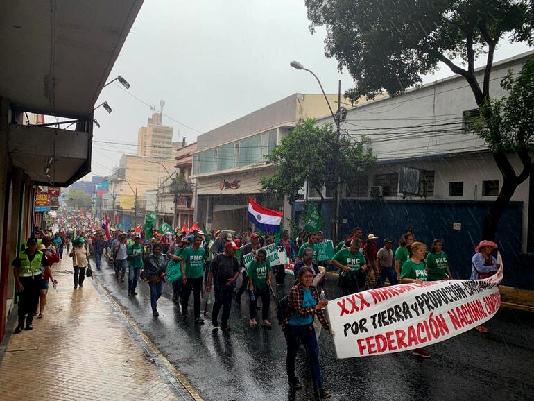 Momento en que empezaba a llover, los campesinos yendo sobre la calle Félix de Azara, llegando a la itersección con Caballero, en el microcentro capitalino.