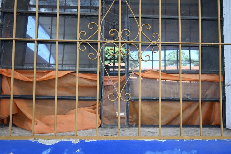 Con una lona tapan la ventana rota en una sala de clase en el Dahlquist.