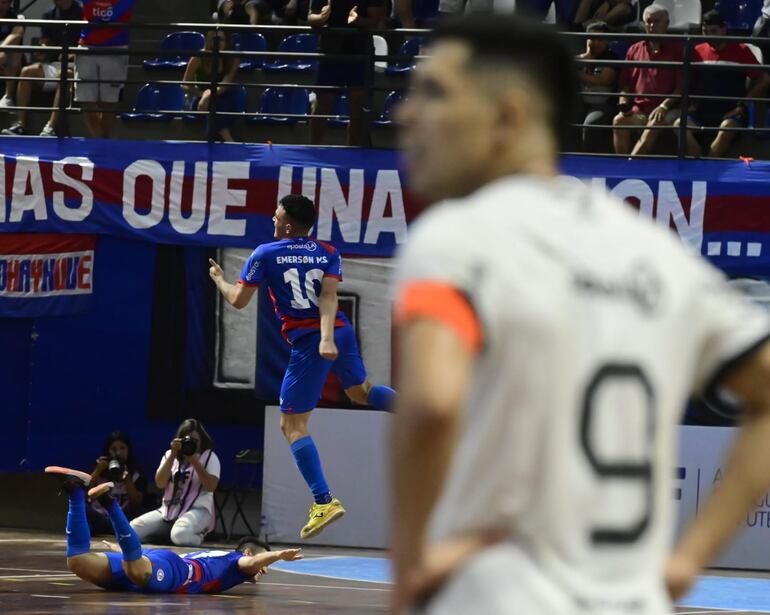 Emerson Méndez, de Cerro Porteño, celebra un gol ante Olimpia, con Hugo Martínez de fondo.