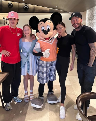 David y Victoria Beckham con sus hijos menores Cruz y Harper posando con Mickey.