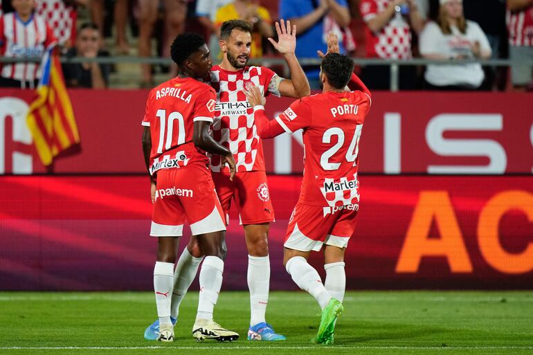 El delantero uruguayo del Girona Cristhian Stuani (c) celebra un gol ante el Osasuna con sus compañeros Portu y Asprilla durante el partido de la jornada 3 de LaLiga EA Sports entre el Girona FC y el CA Osasuna, este jueves en el estadio de Montilivi, en Girona.