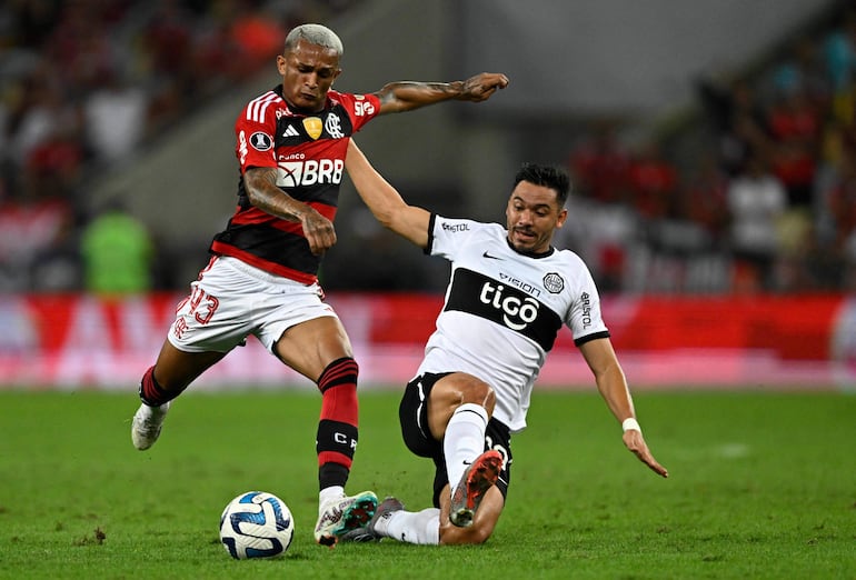 El paraguayo Walter Gonzalez (d), jugador de Olimpia, pelea por el balón en el partido contra Flamengo por la ida de los octavos de final de la Copa Libertadores en el estadio Maracaná, en Río de Janeiro, Brasil.