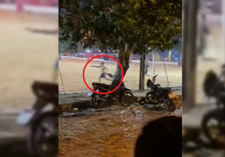 Momento en que uno de los hinchas apunta con un arma de fuego a otras personas durante un enfrentamiento en el club Independiente de barrio Obrero.