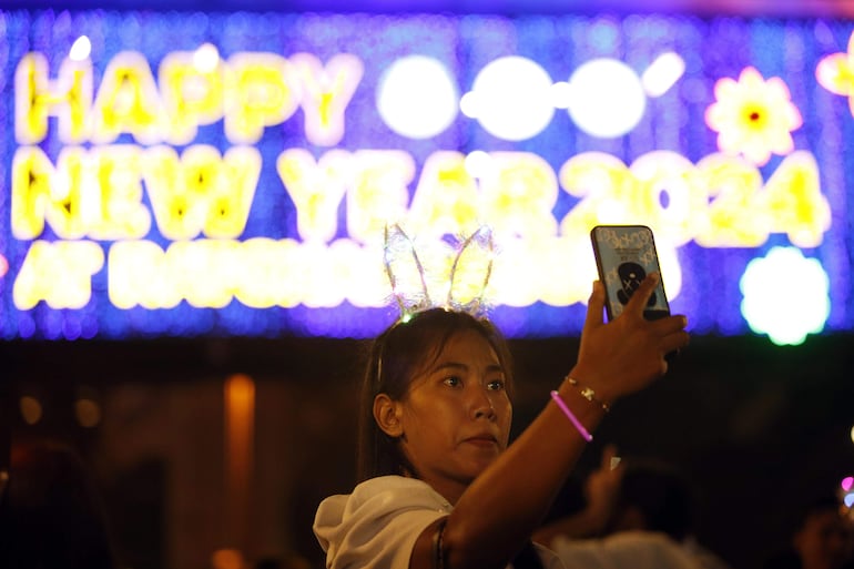 Bangkok (Tailandia), 31/12/2023.- Una mujer toma fotografías selfie para celebrar la víspera de Año Nuevo en Bangkok, Tailandia, 31 de diciembre de 2023. Los tailandeses de todo el país celebran la víspera de Año Nuevo para recibir el año del dragón. (Tailandia) EFE/EPA/RUNGROJ YONGRIT
